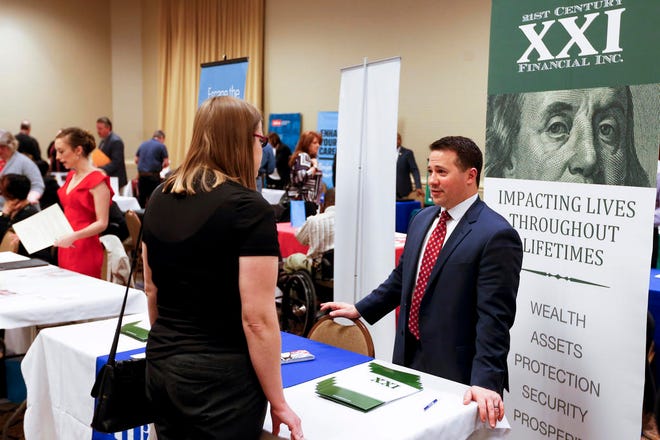 In this Wednesday, March 30, 2016, photo, recruiters speak to attendees at a job fair in Pittsburgh. On Friday, May 6, 2016, the U.S. government issues the April jobs report.