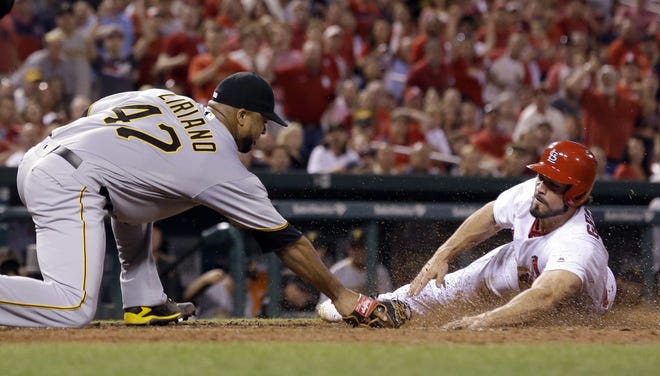 The St. Louis Cardinals' Randal Grichuk, right, is safe at home as he scores on a wild pitch by Pittsburgh Pirates starting pitcher Francisco Liriano on Friday night. THE ASSOCIATED PRESS