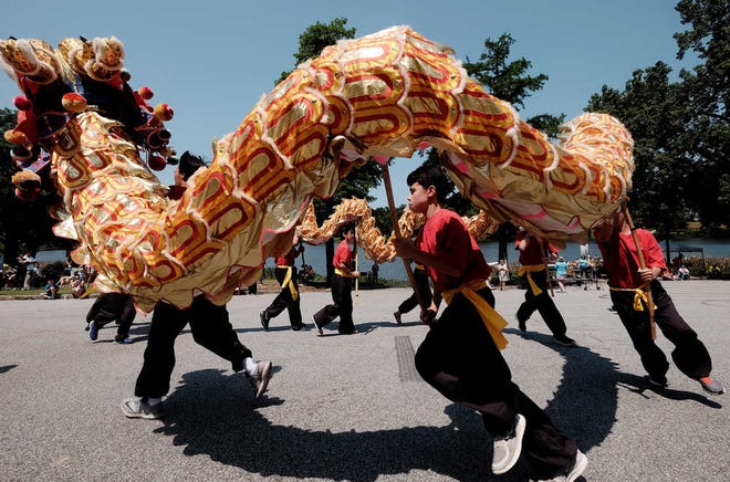 Performers participate in the Dragon Dance during Goodwill's Dragon Boat Races at Lake Olmstead on Saturday. The annual fundraiser for Goodwill features an Asian arts festival on the lake banks.