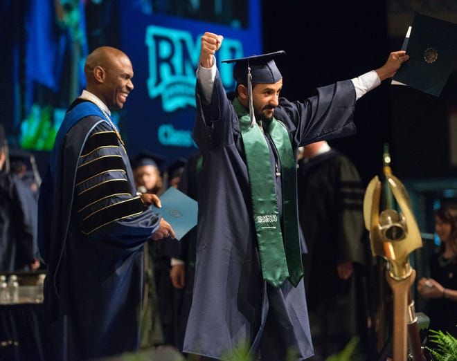 Abdulmalk Saleh Aldayan of Saudi Arabia, right, celebrates his Bachelor of Science in Business Administration degree after receiving his diploma from university President Christopher Howard, left, during commencement exercises at Robert Morris University on Saturday.