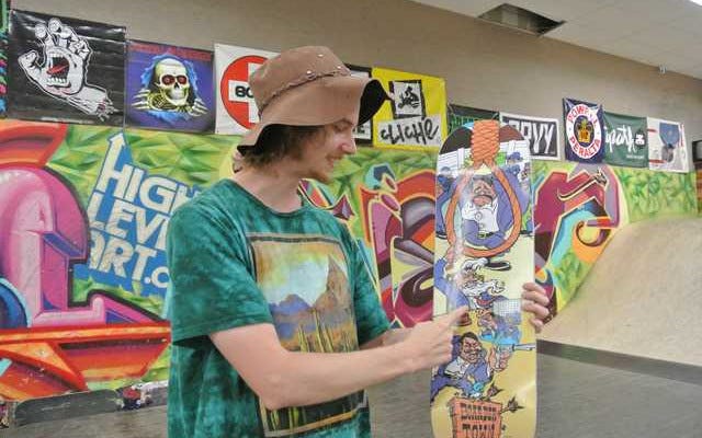 Cartoonist Jason Meadows discusses his new skateboard design at the BoarderTown Skate Shop in Fort Smith Tuesday. Thomas Saccente/Times Record