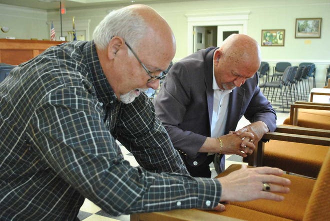 Dr. Bill Eckles, left, pastor at Grove First Baptist church and Tony Henderson pastor at Clifford Memorial Presbyterian Church in Groveotwn, kneel and pray at the Grovetown city hall council chambers during the national day of prayer. City hall was open from 10 a.m. - 3 p.m. for people to stop in and pray.