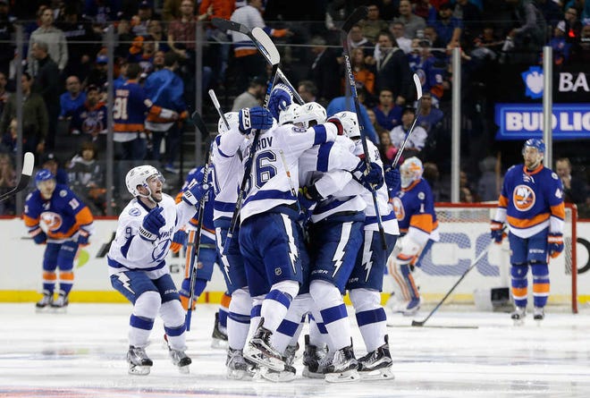 Tampa Bay players celebrate the game-winning goal in overtime by defenseman Jason Garrison in Game 4 of their NHL playoff series. The Lightning won 2-1. Game 5 is Sunday.