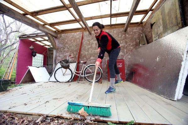 Tamara Sabbagh, co-captain of Ohio State's women's club rowing team, cleans an outdoor photo set at Kent Smith Studio in Pickerington.