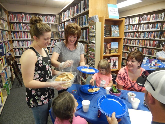 — Monroe News photo by ANDREA PECK
Liz Pifer and her daughter, Bethany, serve pancakes to Karla and Randy Brooks and their daughters, June and Bryn, at Pancakes with Mom, a pancake breakfast hosted at Blue Bush Branch Library Saturday in honor of Mother's Day.