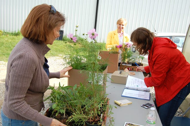 Jan Marchese and Linda Gavel purchase plants at the Hillsdale College Arboretum plant sale Saturday as volunteer Emiley Rinaldi records the sales. NANCY HASTINGS PHOTO