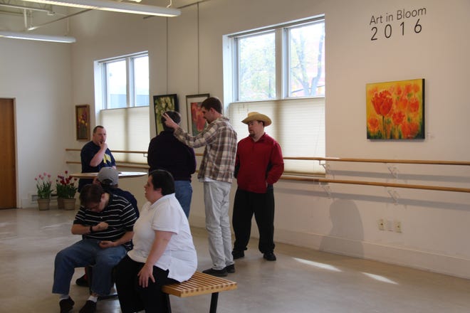 People look ar the Art In Bloom top 20 at the Holland Area Arts Council on Monday. Erin Dietzer/Sentinel Staff