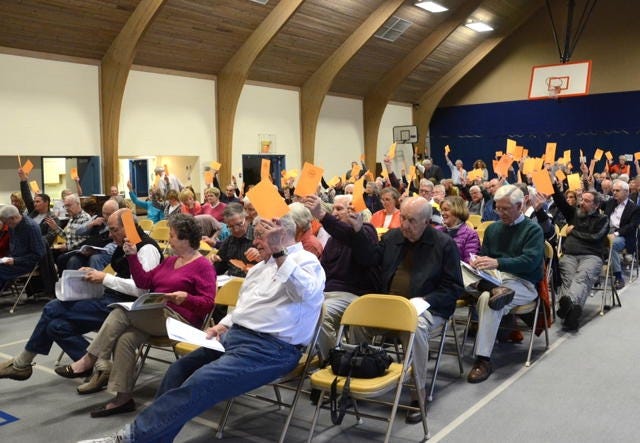 Voters show support for an article during New Castle's Town Meeting held at the recreation center Tuesday night. Suzanne Laurent photo.