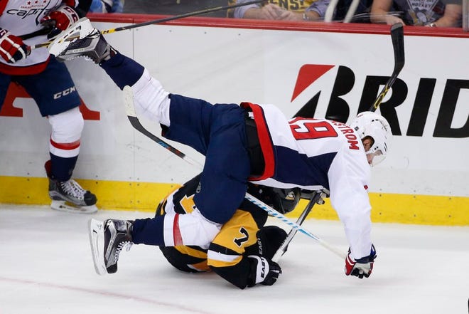 The Capitals' Nicklas Backstrom (19) collides with Matt Cullen of the Penguins.
