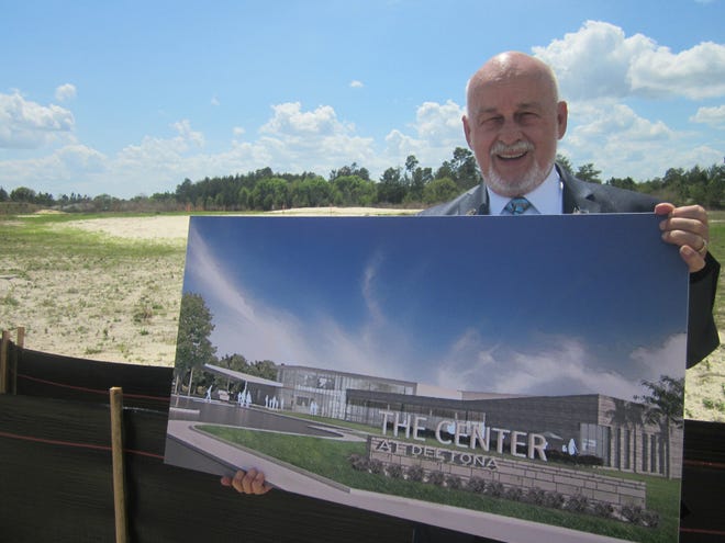 Mayor John Masiarczyk holds a rendering of the planned community center at the site where it will be built. News-Journal/Austin Fuller