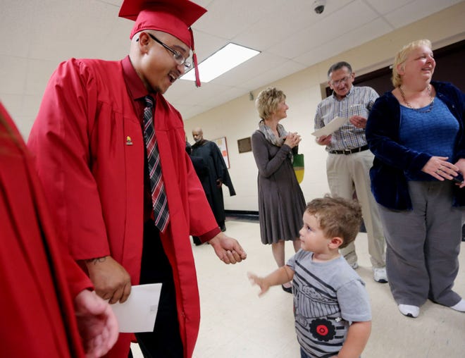 Keaton Underwood is congratulated by his two-year-old son King Underwood, follow Southeastern Community College’s High School Equivalency Graduation Ceremony, Tuesday May 10, 2016 at SCC’s Loren Walker Arena. In total, 178 students will have graduated this year from one of SCC’s campuses with their HiSet and on Tuesday, 11 of the 33 walked across the stage inside Loren Walker Arena.
