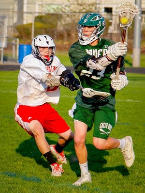 Spaulding's Ashton Langis, left, tries to slow down Dover s Dominic Silverio during interdivision boys lacrosse action Wednesday evening in Rochester. Shawn St. Hilaire/Fosters.com