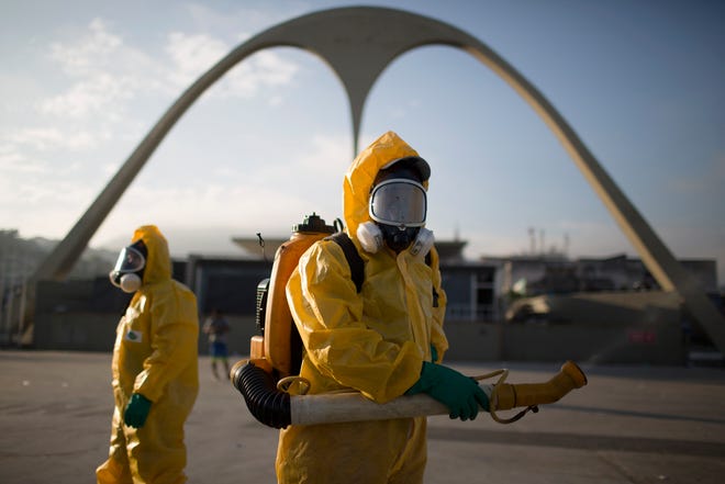 In this Tuesday, Jan. 26, 2016 file photo, a health workers stands in the Sambadrome spraying insecticide to combat the Aedes aegypti mosquito that transmits the Zika virus in Rio de Janeiro, Brazil. The Sambadrome will be used for the Archery competition during the 2016 summer games. With the opening ceremony less than three months away, a Canadian professor has called for the Rio Olympics to be postponed or moved because of the Zika outbreak, warning the influx of visitors to Brazil will result in the avoidable birth of malformed babies. The IOC and World Health Organization disagree, saying Zika will not derail the games.