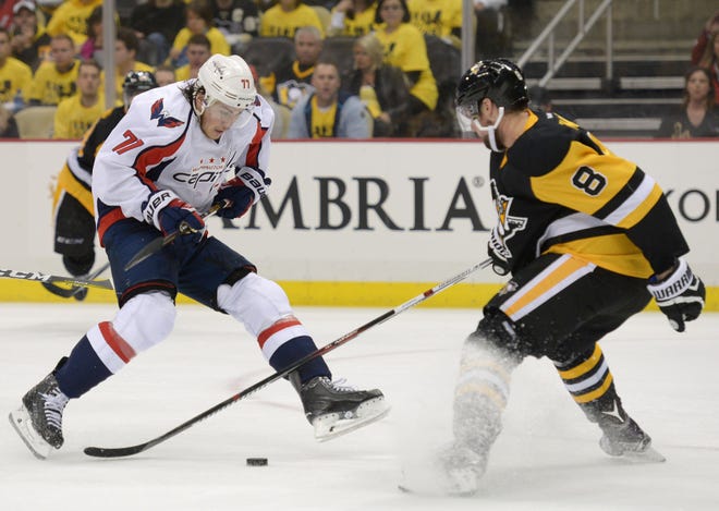 Brian Dumoulin (8) defends as the Washington Capitals T.J. Oshie (77) takes the puck toward the Penguins goal during the third period of Tuesday's Game 6 in the Eastern Conference Semifinals at Consol Energy Center in Pittsburgh.