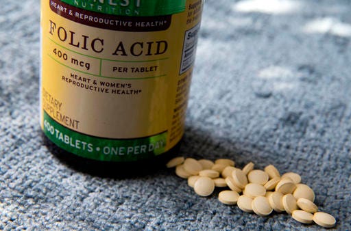 A bottle of folic acid is photographed, Wednesday, May 11, 2016, in New York. A new study suggests very high levels of the vitamin in mothers’ blood at the time of childbirth was linked to higher risk of their children developing autism years later. Other research points to an opposite relationship between folic acid and autism, showing that adequate amounts of the vitamin at the time of conception can significantly reduce the risk.  (AP Photo/Mary Altaffer)