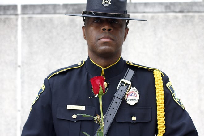 Det. J. L. Darrington, Jr. of the Petersburg Police Honor Guard stands with a single red rose before placing it at the memorial marker for fallen law enforcement officers during a police week memorial ceremony at the Petersburg Bureau of Police headquarters in Petersburg on Wednesday, May 11, 2016. Scott P. Yates/progress-index.com