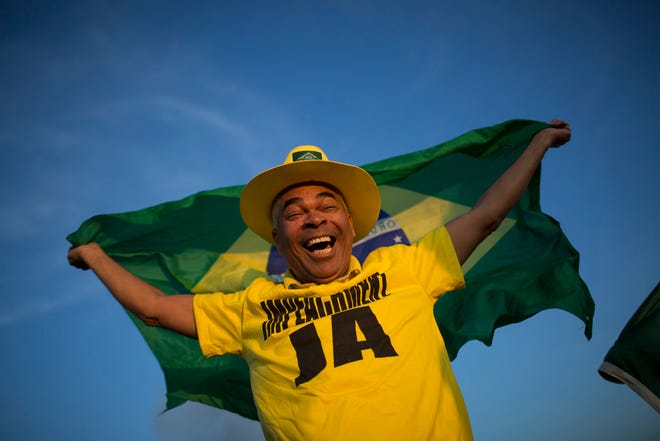 An anti-government demonstrator celebrates the result of the impeachment process outside Congress in Brasilia, Brazil, Thursday. Brazil's Senate voted Thursday to impeach President Dilma Rousseff just months before it hosts the Summer Olympics.