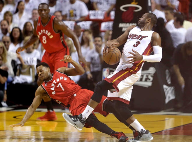 Miami Heat's Dwyane Wade (3) collides with Toronto Raptors' Kyle Lowry (7) as he makes a move to the basket during the first half of Game 6.