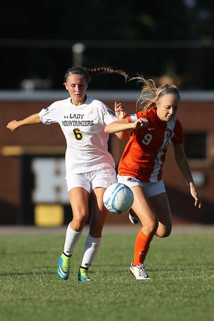 Kings Mountain's Virginia Dellinger, left, pushes to win the ball against Marvin Ridge's Kelsey Lynch on Friday night during the second round of soccer playoffs at John Gamble Stadium in Kings Mountain. Hannah Covington/The Star