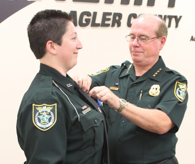 Flagler County Sheriff Jim Manfre pins the FCSO badge on new detention Deputy Danielle Basciano. PHOtO PROVIDED/FLAGLER COUNTY SHERIFF'S OFFICE