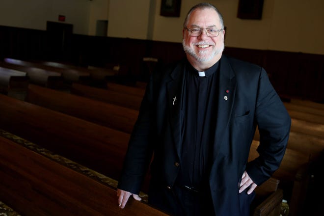 The Rev. Carl Mann, the new pastor of Christ Espicopal Church, stands Thursday among pews in the church in Burlington.