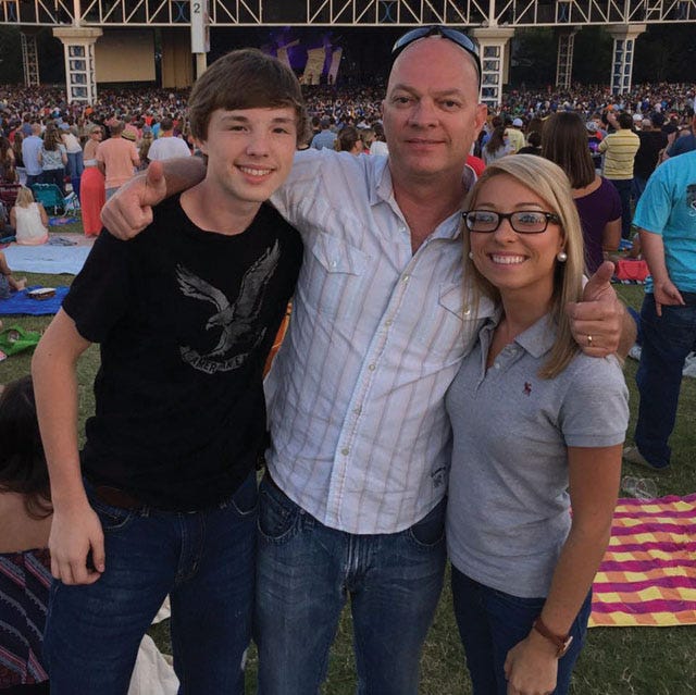 Former Hugo firefighter Jay Tyndall stands with his children Ian, left, and Ashley, right, at a Dave Matthews Band concert in Bristow, Va., in May 2015.