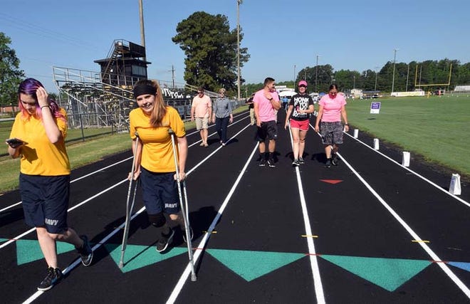 Shawna Rigby, 16, didn’t let a knee brace and crutches keep her from walking in the Pamlico County Relay with her friend Kaitlyn Simpson, left. Photo by Charlie Hall/Sun Journal Staff