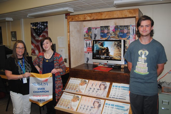 Displaying the newsstand BOCES used in state competition are, from left, Courtney Potter, SkillsUSA co-adviser with Bernie Riley, and students Sidney Stein and Gary Havens. BRIAN QUINN/DAILY REPORTER
