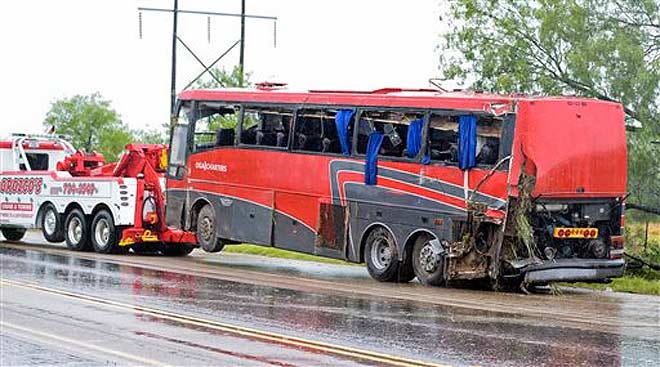 A damaged OGA Charters bus is hauled away after a fatal rollover on Saturday, May 14, 2016, south of the Dimmit-Webb County line on U.S. Highway 83 North in Texas.