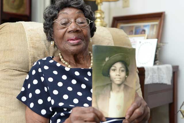Sudie Gooding, a lifetime Kinston resident, holds a photo of herself as a young woman on Thursday in her Daniel Street home.