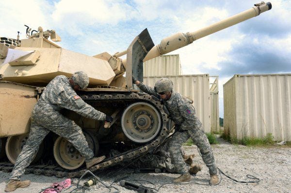 Army 1st Lt. John Dupre, left, and Army Sgt. Curtis Bowen, both with the N.C. Army National Guard's C Company, 1st Battalion, 252nd Armored Regiment, work to replace a section of track on an M1A2 Abrams tank during the Sullivan Cup competition earlier this month in Fort Benning, Ga.