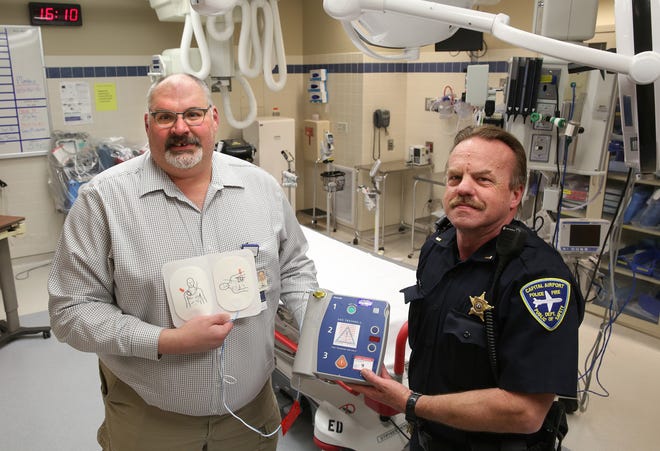 Brian Churchill, left, and Robert Gonterman show off an automated external defibrillator Monday at HSHS St. John’s Hospital similar to one they and Churchill’s wife, Lisa, used to save a man’s life last year. David Spencer/The State Journal-Register