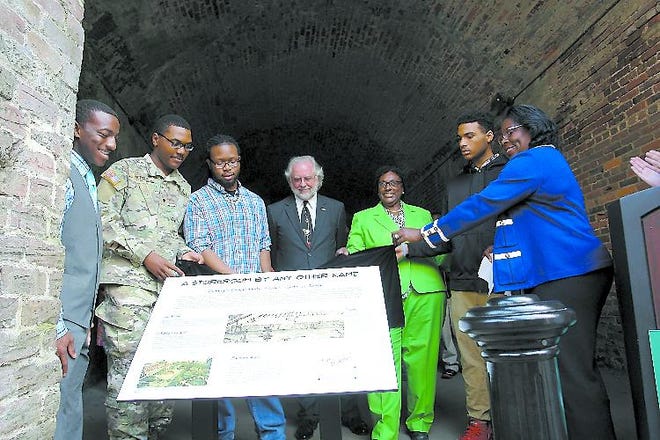 Mayor Pro Tem Carol Bell, Alderman Bill Durrence and Aldermwoman Estella Shabazz are joined by members of the Shinhoster Youth Leadership Group during Wednesday's unveiling of new interpretive panels telling the history of the Cluskey Embankment Stores. Special to the Savannah Morning News
