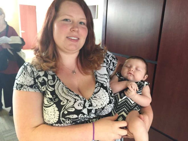 Jessica Segrest, holding her 2-month-old daughter Winry, spoke to the Augusta Commission about hardships facing residents of Patterson Bridge Road.