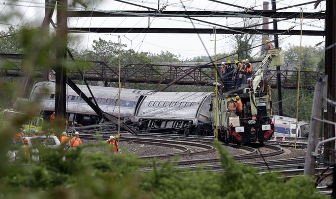 Emergency personnel work at the scene of a deadly train derailment, Wednesday, May 13, 2015, in Philadelphia. The Amtrak train, headed to New York City, derailed and crashed in Philadelphia on Tuesday night, killing at least six people and injuring dozens of others. (AP Photo/Mel Evans)