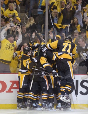 Evgeni Malkin (71) leaps onto his teammates as they celebrate Sidney Crosby's game-winning goal during overtime of Game 2 of the Eastern Conference final on Monday at Consol Energy Center in Pittsburgh.