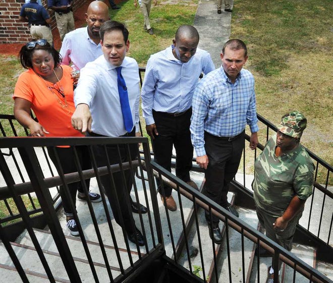 Tracy Grant (from left), Pastor Mark Griffin, Senator Marco Rubio (right), City Councilman Garrett Dennis, Mayor Lenny Curry, and Gail Thomas take a tour of Eureka Garden apartments Friday.