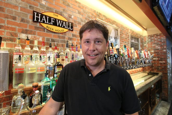 Brandon McKenney, president of the family's restaurant business, stands before the Half Wall Beer House bar on Canal Street in New Smyrna Beach that offers 76 different craft beers on tap. The family is opeing a Half Wall in Port Orange in July and a second New Smyrna Beach location later in the year, both of which will offer 100 craft beers on tap. News-Journal/Jim Tiller
