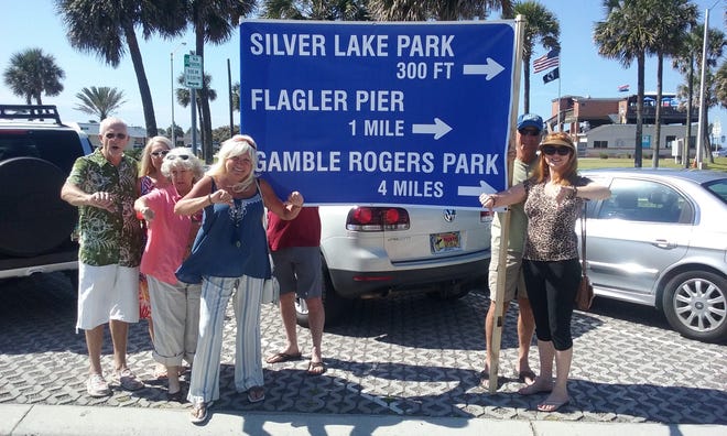 Standing with their version of a way-finding sign are Flagler Beach residents, from left, Sanford Simon, Margie Simon, Martha Rhudy, Dorothy Strickland, Jack Davis (partially hidden), Bill Mount and Beth Mount in April. While the sign is not fashioned in the style that was proposed for those along State Road A1A, Strickland said it is the same size and many residents opposed them. NEWS-JOURNAL FILE/SHAUN RYAN