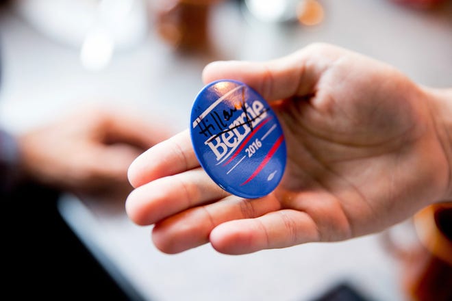 A man displays a Bernie Sanders campaign button that Democratic presidential candidate Hillary Clinton signed as she greets patrons at Lone Oak Little Castle Restaurant in Paducah, Ky., Monday, May 16, 2016. (AP Photo/Andrew Harnik)