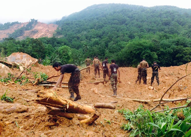 Sri Lankan army soldiers look for survivors at scene after a massive landslide in Kegalle district, about 72 kilometers (45 miles) north of Colombo, Sri Lanka, Thursday, May 19, 2016. Heavy rains Thursday pounded the central Sri Lankan region where at least three villages have already been swallowed by mountains of mud, forcing soldiers and police to suspend rescue work. (AP Photo/Eranga Jayawardena)