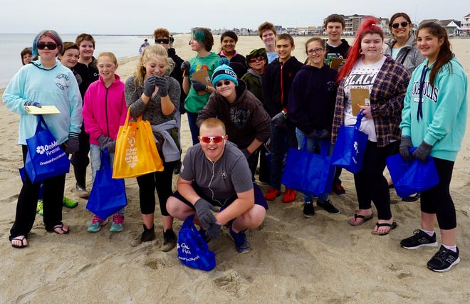 Some of the 40 Seabrook Middle School Interact, Youth to Youth, and National Junior Honor Society members took a short break while picking up 27 pounds of litter at their annual beach cleanup with the Blue Ocean Society for Marine Conservation at Hampton Beach Tuesday.  Some of the items the students collected included plastic biofilm chips that were released by a March, 2011 sewage treatment plant accident in Hooksett. Photo by Kiki Evans/Seacoastonline