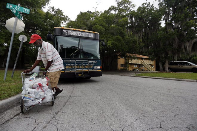 Washington Powers, 65, gets off the bus in the Holly Heights neighborhood after a morning of grocery shopping that took him almost three hours to complete due to logistics of riding the bus.