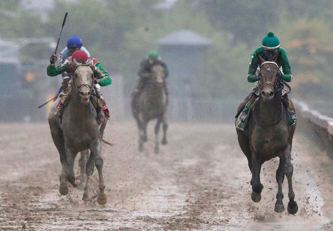Exaggerator, right, with Kent Desormeaux aboard wins the 141st Preakness Stakes horse race at Pimlico Race Course.