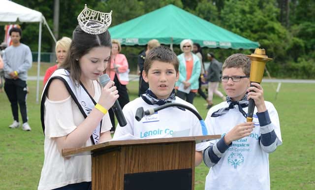 From left, Kendall Neathery, 2016 Miss Neuse, and Thoran Chandler announce the start of the Special Olympics as Cody Bridgers holds the Olympic torch on Friday at Kinston High School.
