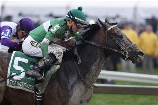 Exaggerator (5), with Kent Desormeaux aboard, moves past Nyquist (3), with Mario Gutierrez riding, during the 141st Preakness Stakes on Saturday. AP Photo/Garry Jones