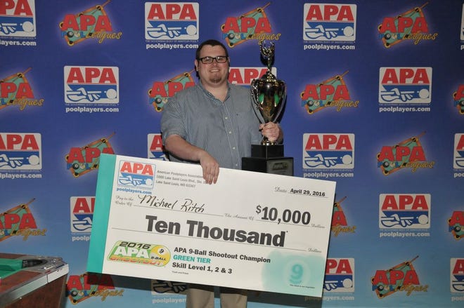 Michael Ritch stands with his prize check after winning the American Poolplayer Association's9-Ball Shootout.