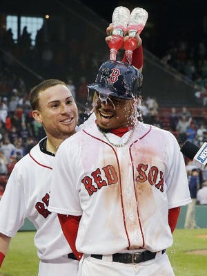 Christian Vazquez, left, douses Mookie Betts after Saturday's game.