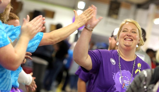 Ann Hamrick gets a high five while walking the survivors' lap inside Dorton Hall at Relay For Life on Friday. Brittany Randolph/The Star