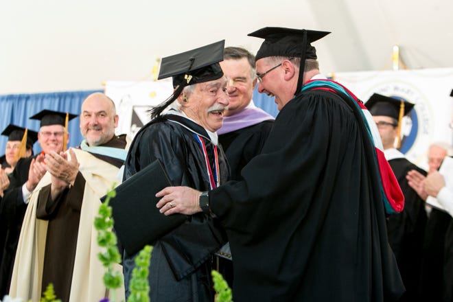 Alvin Mann, left, receives his diploma at Saturday's commencement at Mount Saint Mary College in Newburgh. The 92-year-old Cuddebackville resident earned a bachelor's degree in history. Allyse Pulliam/For the Times Herald-Record